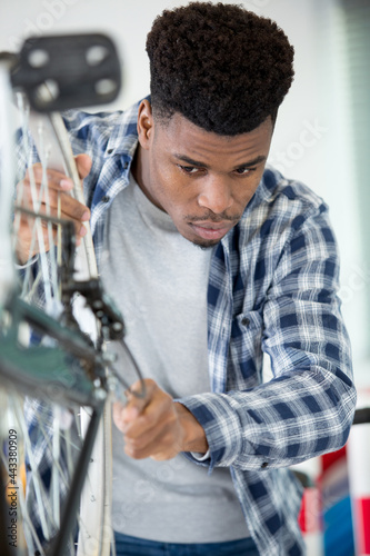 male mechanic working on bicycle wheel