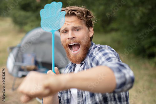 man trying to get rid of annoying insects