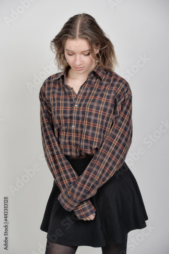 junge frau sexy schlank taille figur stehend in strumpfhosen nylons rock schulmädchen und bluse karohemd schüchtern photo