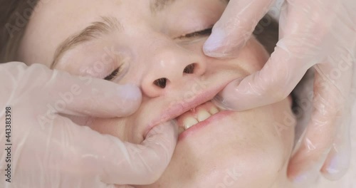 Close-up buccal massage. Massage of the face and nasal folds, deep facial massage of a young woman. Spa salon photo