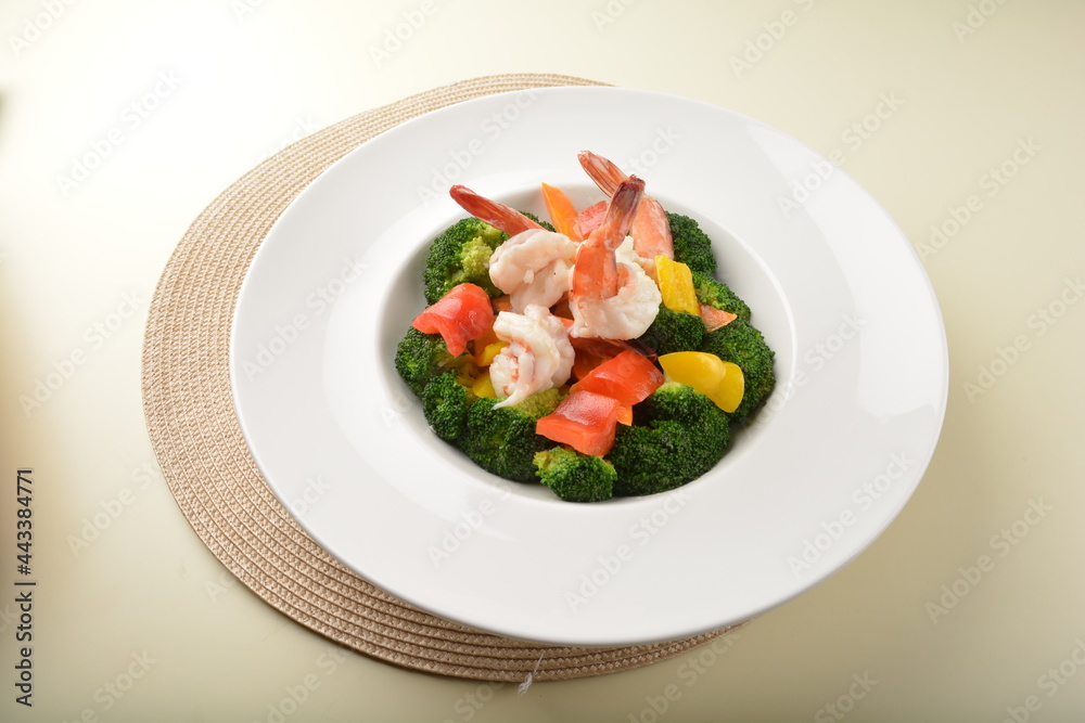stir fried green broccoli with fresh big tiger prawn and bell pepper in oyster sauce in white plate asian halal menu stir fried green broccoli with fresh big tiger prawn and bell pepper in oyster sauce in white plate asian halal menu