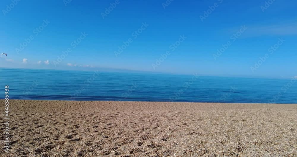 Beautiful shot panning across an empty British beach with sand in summer Beautiful shot panning across an empty British beach with sand in summer