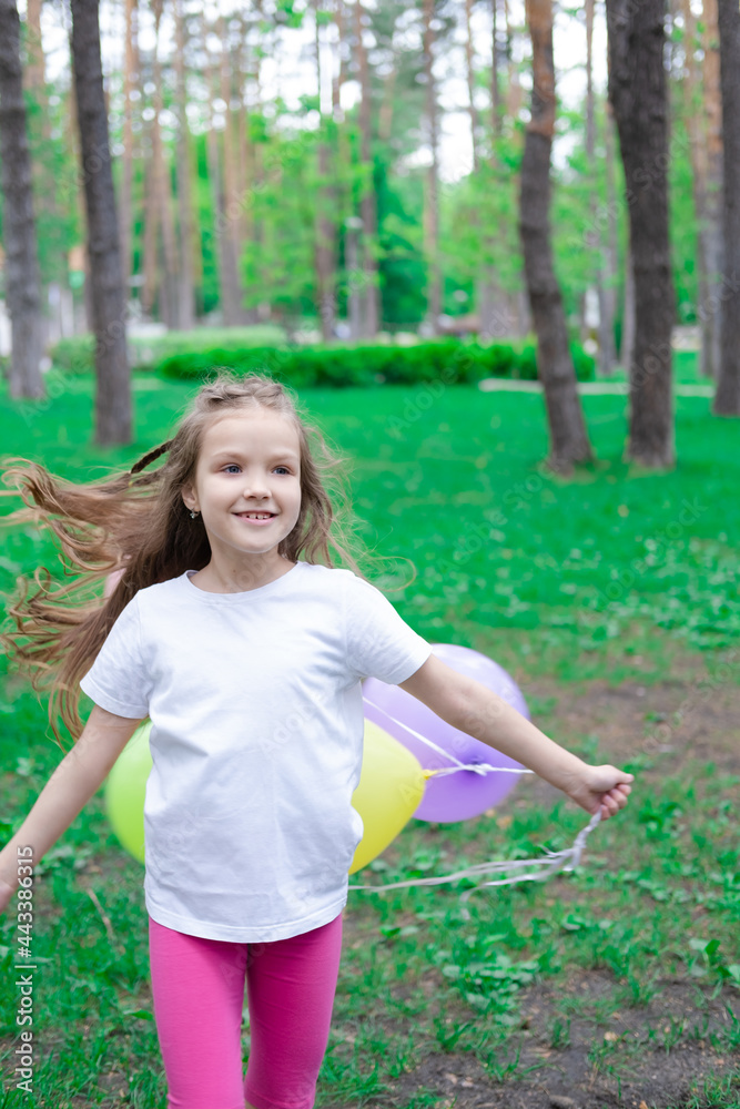 pretty preschool girl having fun playing with hot air balloons outdoors. hollidays, party, birthday, celebration. happy children pretty preschool girl having fun playing with hot air balloons outdoors. hollidays, party, birthday, celebration. happy children