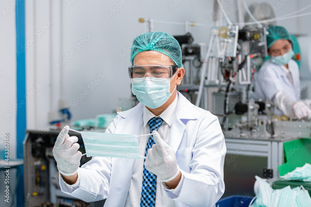 Man worker wear uniform are checking quality medical mask of manufacturer factory. face mask industry factory. manufacturer medical equipment. Man worker wear uniform are checking quality medical mask of manufacturer factory. face mask industry factory. manufacturer medical equipment.