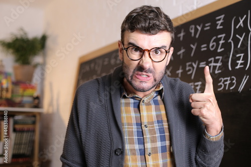 Angry teacher pointing with finger in classroom