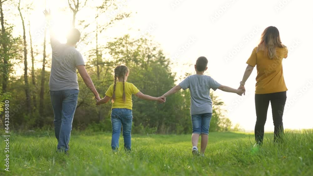Happy family. Parents and child walk in park. People walk in nature. Happy family in green field. Parents and child in nature at sunset. Happy family concept. Group of people in green grass in park Happy family. Parents and child walk in park. People walk in nature. Happy family in green field. Parents and child in nature at sunset. Happy family concept. Group of people in green grass in park