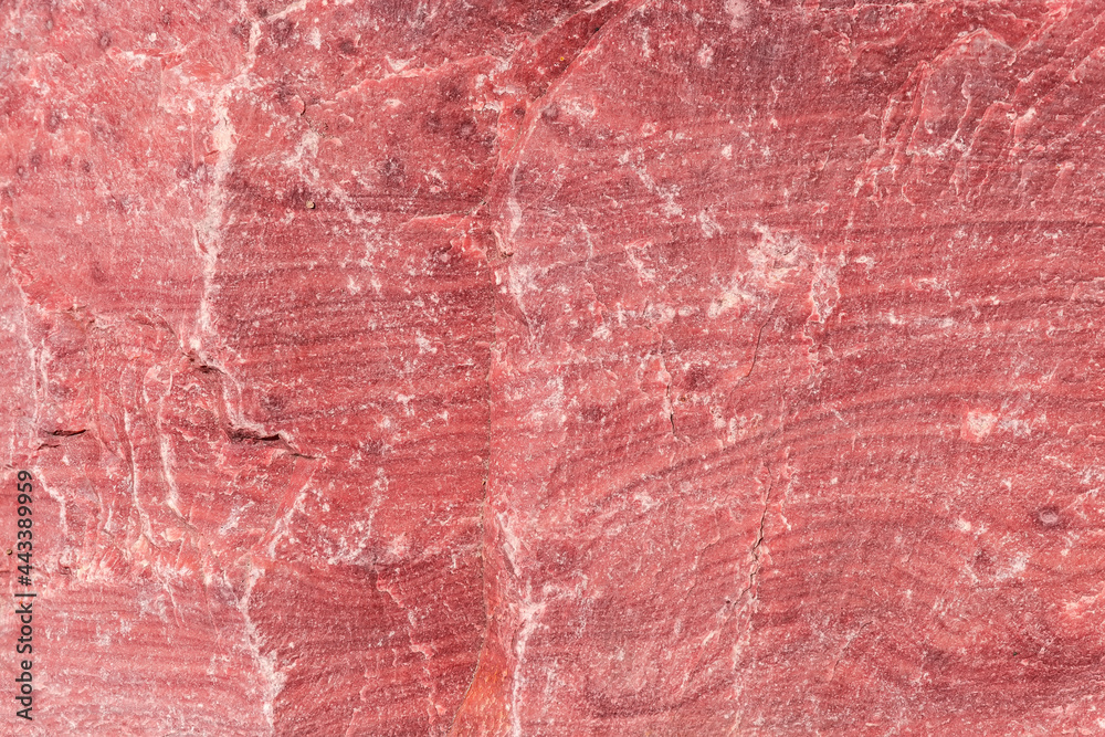 Texture of rough torn edge of slightly layered red stone