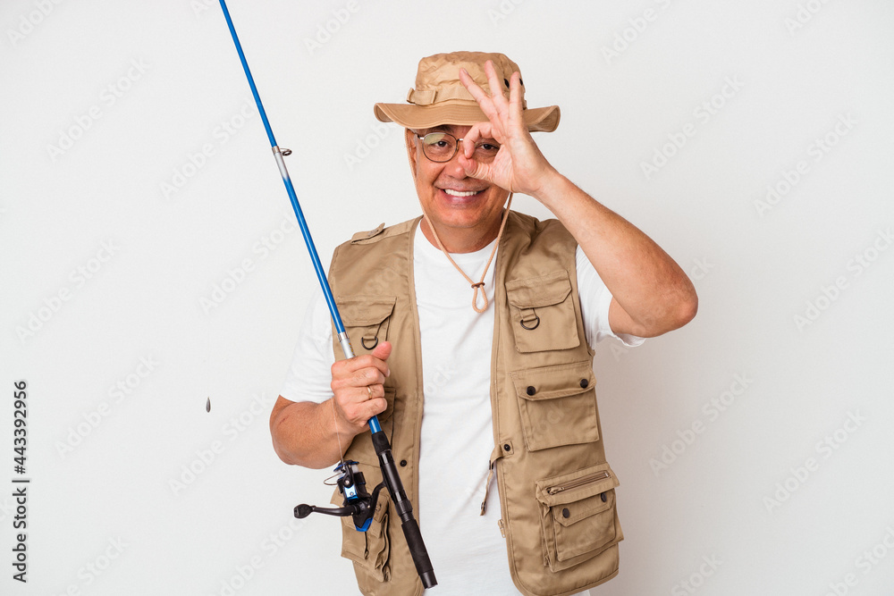 Senior american fisherman holding rod isolated on white background excited keeping ok gesture on eye. Senior american fisherman holding rod isolated on white background excited keeping ok gesture on eye.