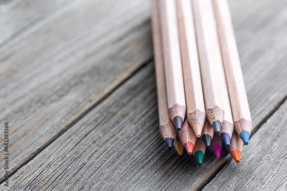 Close up of colored pencils on a wooden surface.