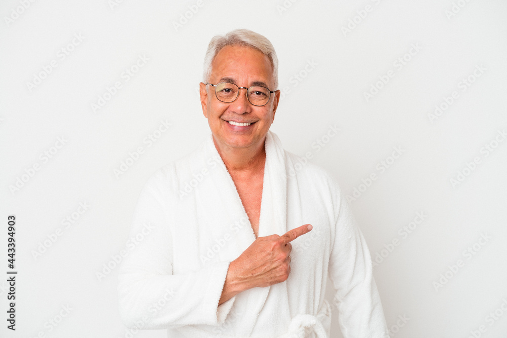 Senior american man wearing bathrobe isolated on white background smiling and pointing aside, showing something at blank space. Senior american man wearing bathrobe isolated on white background smiling and pointing aside, showing something at blank space.