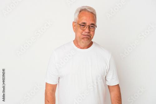 Senior american man isolated on white background blows cheeks, has tired expression. Facial expression concept.