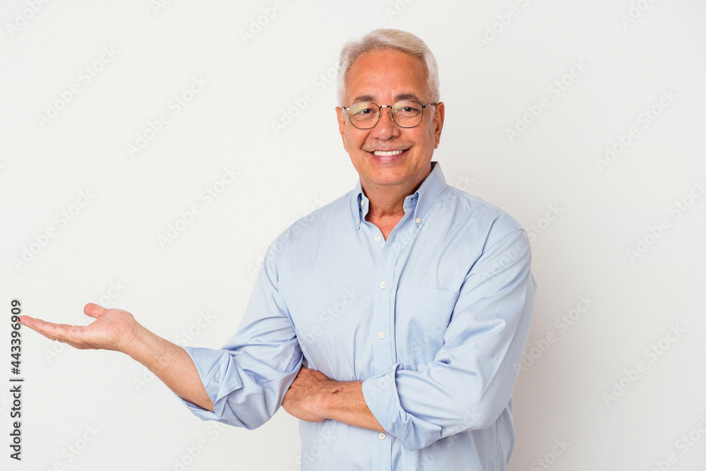 Senior american man isolated on white background showing a copy space on a palm and holding another hand on waist. Senior american man isolated on white background showing a copy space on a palm and holding another hand on waist.
