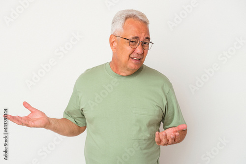 Senior american man isolated on white background doubting and shrugging shoulders in questioning gesture.