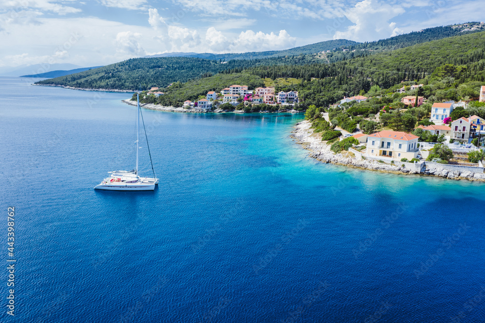 Sailing yacht boat in blue sea arrive Fiscardo village in Kefalonia island, Greece