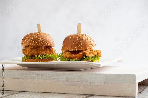 mini Chicken burgers with lettuce and sticks on a wooden background