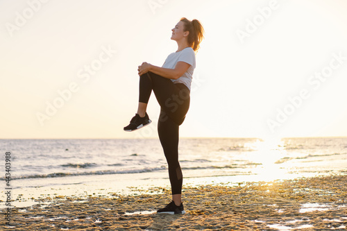 Young girl doing yoga fitness exercise outdoor in beautiful sea and morning sunrise. lifestyle.