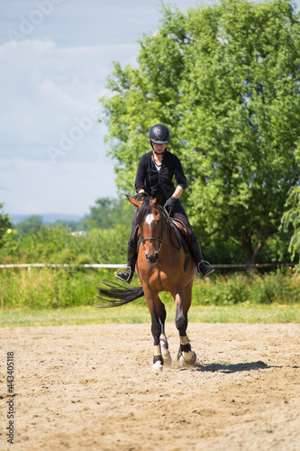 Girl in in competition uniform gallops on horseback