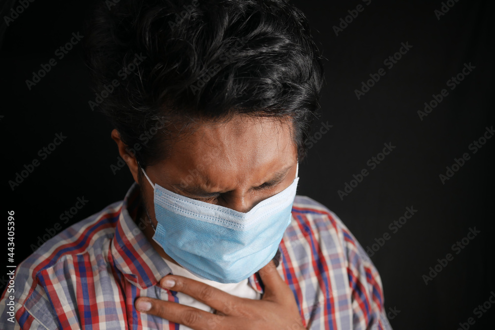 young sick man coughing and sneezes isolated on black young sick man coughing and sneezes isolated on black