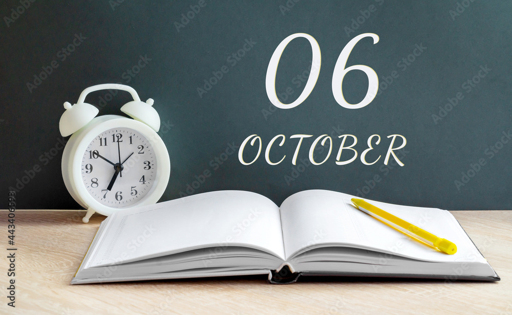 october 06. 06-th day of the month, calendar date.A white alarm clock, an open notebook with blank pages, and a yellow pencil lie on the table.Autumn month, day of the year concept october 06. 06-th day of the month, calendar date.A white alarm clock, an open notebook with blank pages, and a yellow pencil lie on the table.Autumn month, day of the year concept