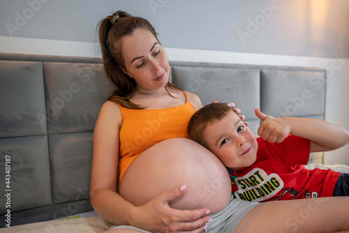 Happy boy with his pregnant mother. Mothers day concept photo