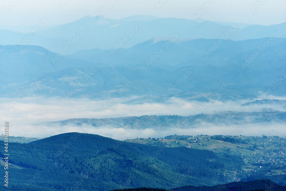 Beautiful landscape background, alpine valley village in cold fog