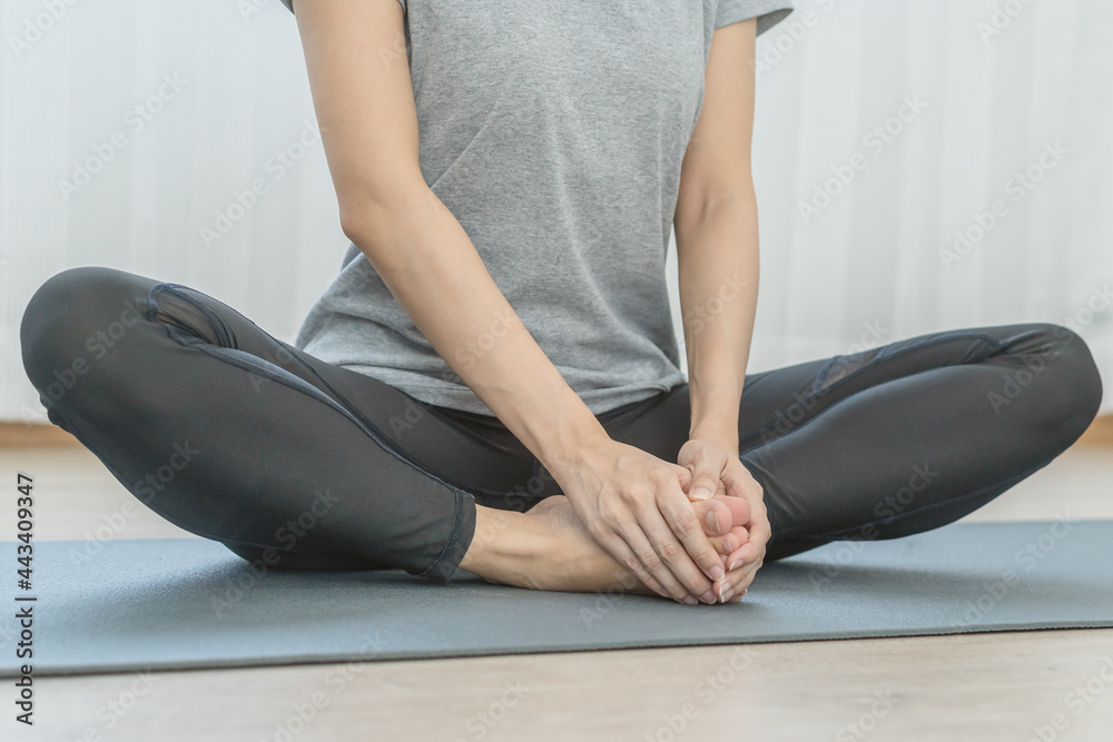 Fototapeta premium Meditating,asian young woman, girl practice yoga in lotus position, calm pose for meditation, exercise on mat for wellbeing, healthy care in room at home. Workout fitness exercise, sport in sportswear