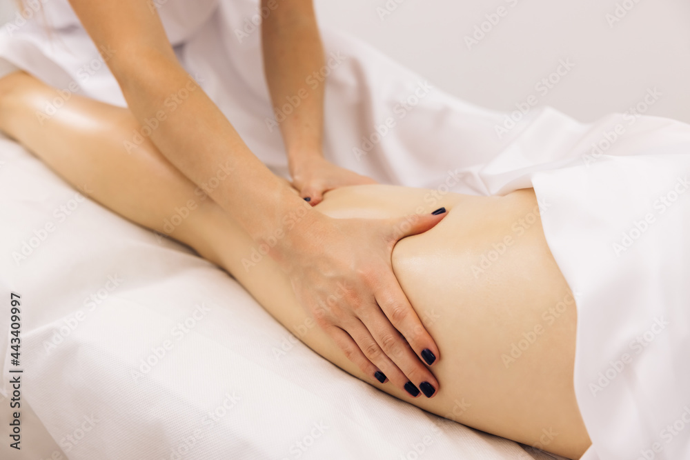 Masseur is doing massage of back of woman lying in beauty salon. Professional is massaging and touching skin of female client, using traditional techniques. Specialist works with body of patient. Masseur is doing massage of back of woman lying in beauty salon. Professional is massaging and touching skin of female client, using traditional techniques. Specialist works with body of patient.