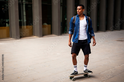Portrait of happy african-american man with skateboard. Young handsome man with skateboard outdoors.