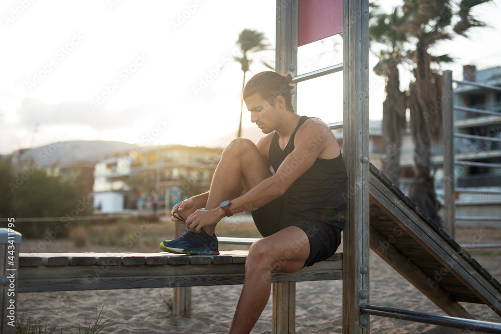 Sporty athletic man exercises at the beach. Handsome man training outdoors.. Sporty athletic man exercises at the beach. Handsome man training outdoors..