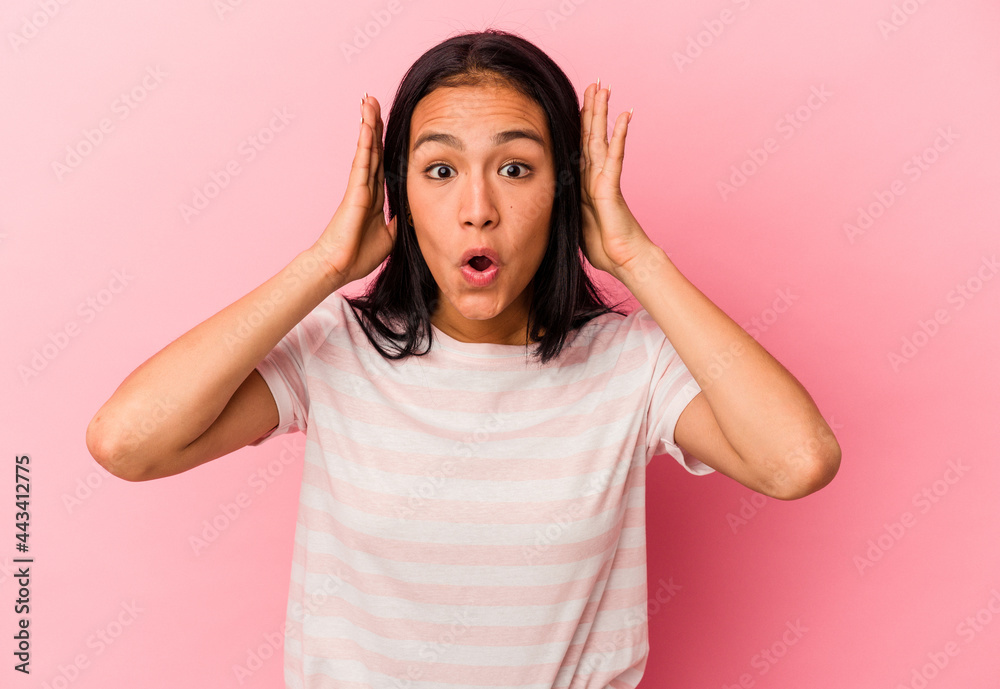 Young Venezuelan woman isolated on pink background surprised and shocked.