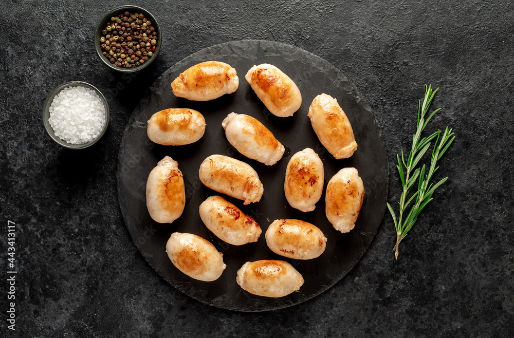 small grilled sausages on a stone background small grilled sausages on a stone background