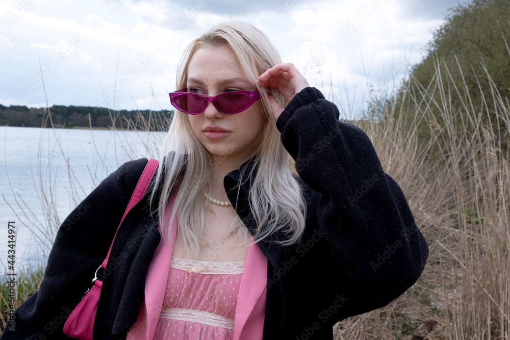 Young teenage girl by lake with purple sunglasses on Young teenage girl by lake with purple sunglasses on