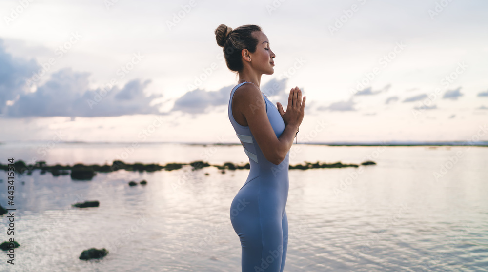 Calm Caucasian yogi keep praying in namaste during time for sportive evening at seashore, tranquil girl enjoying zen asana for feeling harmony of soul and mindfulness during meditation practice Calm Caucasian yogi keep praying in namaste during time for sportive evening at seashore, tranquil girl enjoying zen asana for feeling harmony of soul and mindfulness during meditation practice