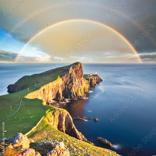 Wonderful sunset with rainbow at the Neist point lighthouse in Scotland photo