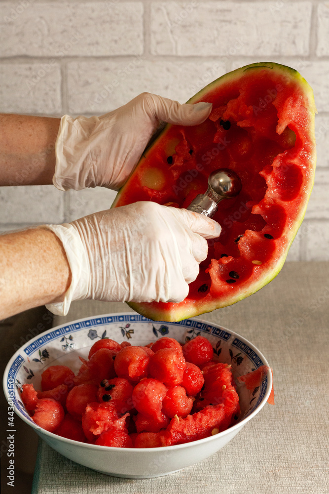Person carving watermelon balls