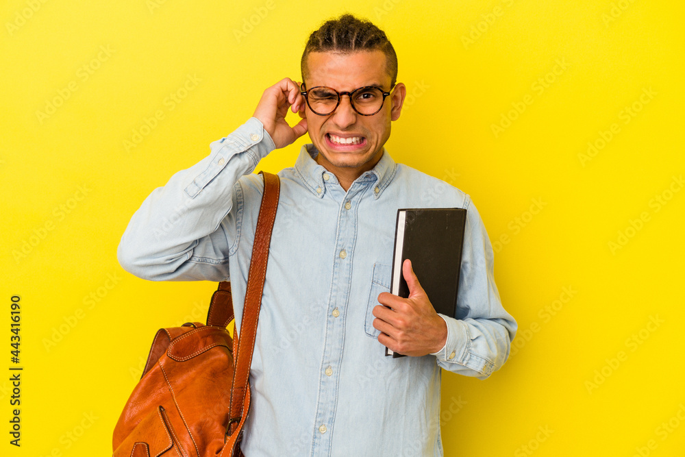 Young venezuelan student man isolated on yellow background covering ears with hands. Young venezuelan student man isolated on yellow background covering ears with hands.