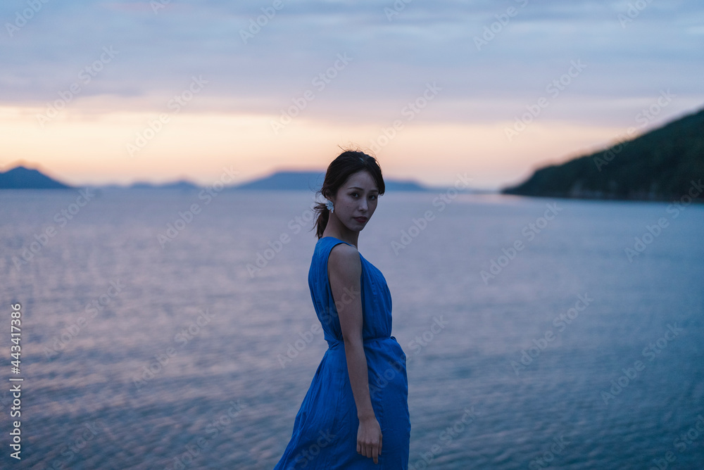 夕暮れの海にいる女性