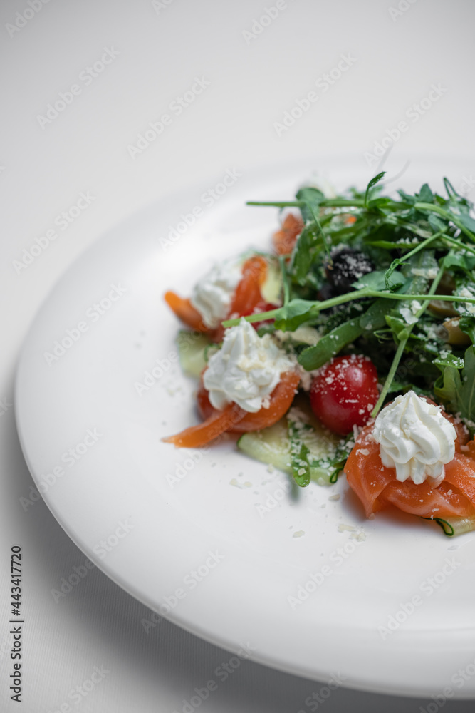 closeup of salad with salted salmon, cream cheese or arugula on white background