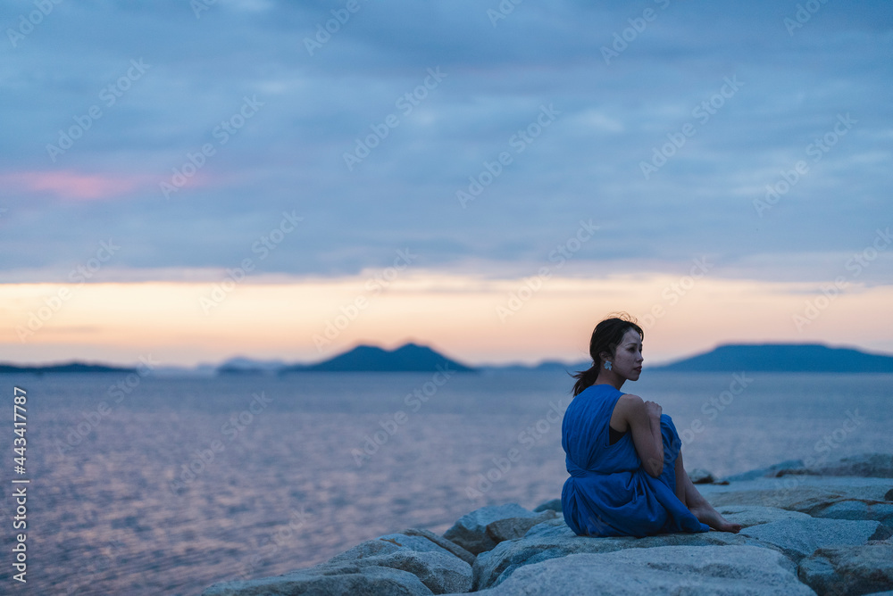 夕暮れの海にいる女性