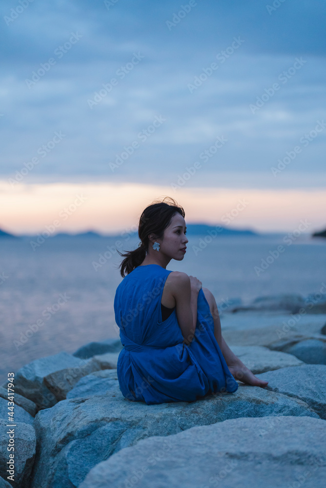 夕暮れの海にいる女性