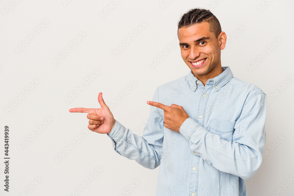 Young venezuelan man isolated on white background pointing with forefingers to a copy space, expressing excitement and desire. Young venezuelan man isolated on white background pointing with forefingers to a copy space, expressing excitement and desire.