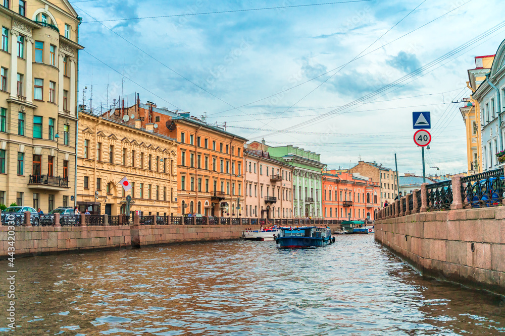 Beautiful view of the Neva river canal in the city center with tourist excursion boats, postcard view. Saint Petersburg, Russia - 28 June 2021