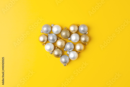Christmas minimal composition with grey and beige ball on yellow background. Flat lay, copy space