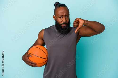 African american man playing basketball isolated on blue background showing a dislike gesture, thumbs down. Disagreement concept.