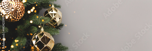 Banner with gold Christmas decorations. New Year baubles in front of gray background with copy space. © rorygezfresh