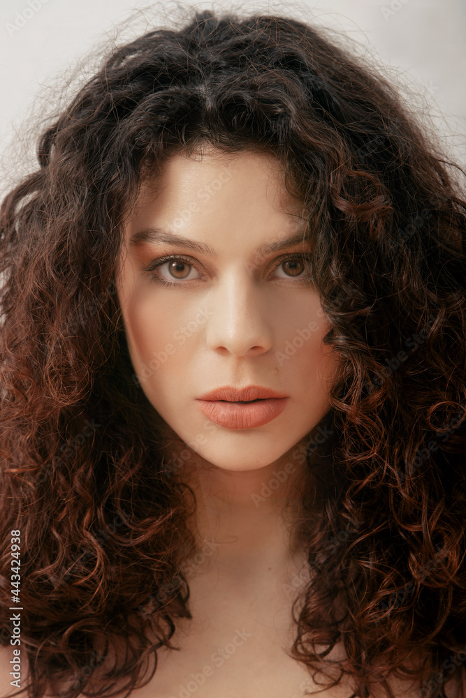 Delighted curly haired woman in studio Delighted curly haired woman in studio