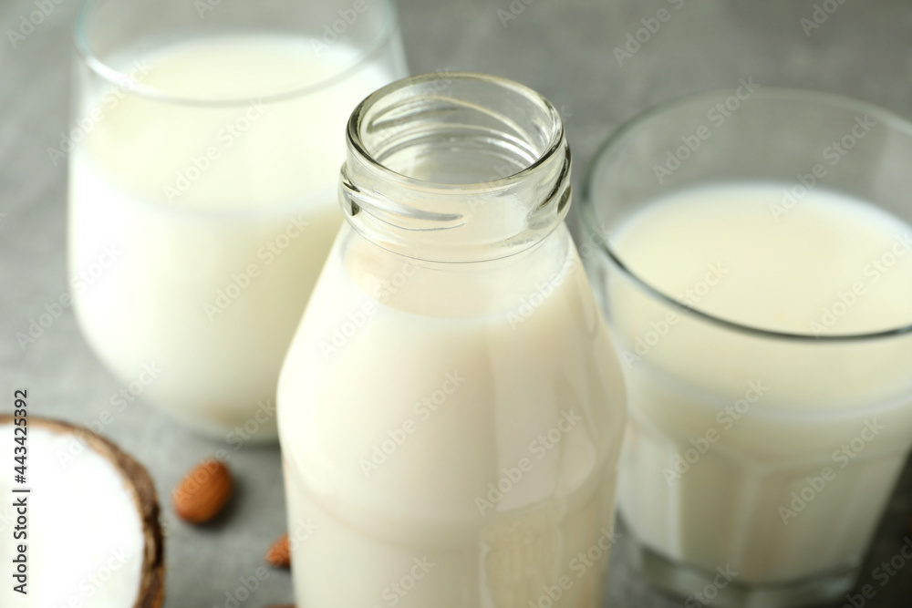 Bottle and glasses with milk, coconut and almond, close up Bottle and glasses with milk, coconut and almond, close up