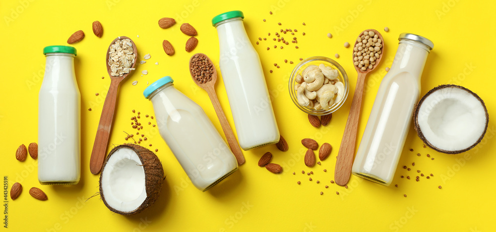 Concept of vegan milk on yellow background, top view Concept of vegan milk on yellow background, top view