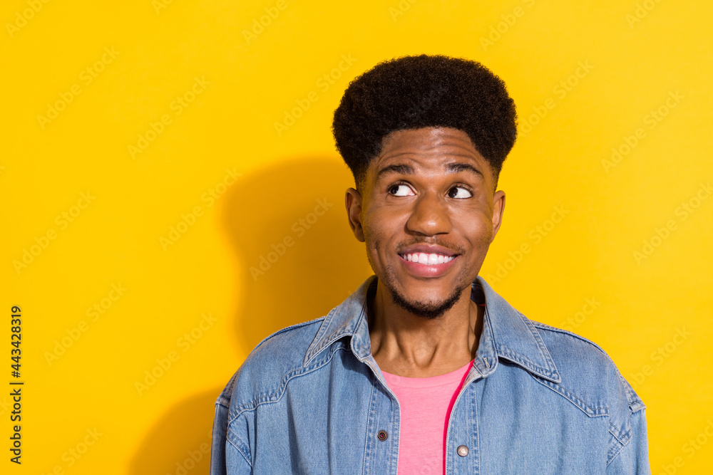 Obraz premium Photo of young happy afro american cheerful man look empty space dream isolated on yellow color background