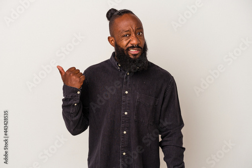 African american man with beard isolated on pink background shocked pointing with index fingers to a copy space.